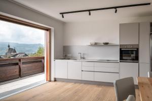 阿特湖畔施泰因巴赫Kaisigen43的一间厨房,配有白色的橱柜和大窗户