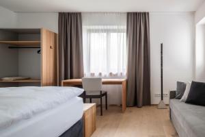 阿特湖畔施泰因巴赫Kaisigen43的配有一张床和一张书桌的酒店客房