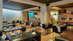 雷克雅未克Thingholt by Center Hotels的一间带桌椅的餐厅和一间酒吧
