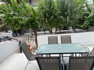 雅典Comfortable Apartment Near to Metro & Hospitals的绿树成荫的庭院里摆放着绿色的桌椅