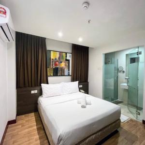 吉隆坡吉隆坡弗仁兹酒店的一间卧室设有一张大床和玻璃淋浴间