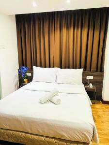 吉隆坡吉隆坡弗仁兹酒店的一张白色的大床,上面有毛巾