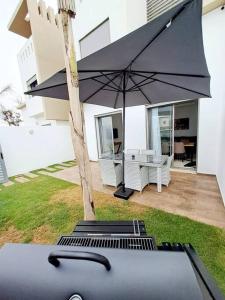 阿加迪尔Luxury Villa sea view的房子院子中的一把黑伞