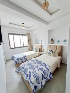 阿加迪尔Luxury Villa sea view的一间卧室配有两张带蓝白色床单的床