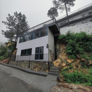 穆克缇斯瓦Hotel Pearl Residency的一座白色的山丘建筑,前面设有楼梯