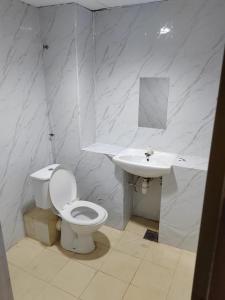 哥打巴鲁Hotel Kenangan的白色的浴室设有卫生间和水槽。