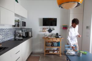 孔韦尔萨诺Casa mia in Puglia的站在厨房里,有桌子的女人
