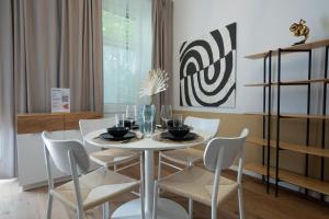 维也纳46 m2 central bright apartment with a balcony的一间配备有白色桌椅的用餐室