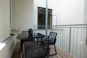 维也纳46 m2 central bright apartment with a balcony的阳台配有桌椅和窗户。