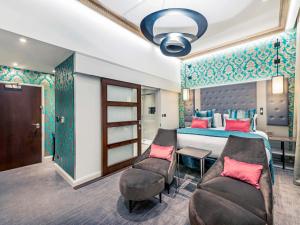 伦敦伦敦海德公园美居酒店的一间卧室配有一张床、一张沙发和一张桌子