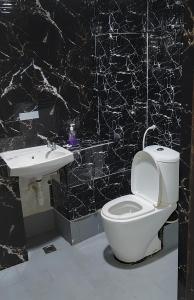 哥打巴鲁Hotel Kenangan的黑白浴室设有卫生间和水槽