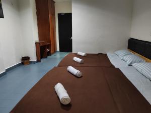 哥打巴鲁Hotel Kenangan的一间设有一张床铺的房间,床上配有滚毛巾