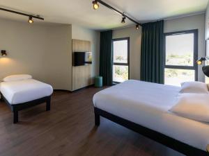 马里尼亚讷Ibis Marseille Marignane Technopole的酒店客房设有两张床和电视。