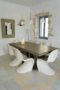 圣玛丽亚Kalma villa的一间带桌子和白色椅子的用餐室