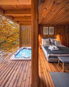 诺茨瓦约TreeHouses Noszvaj的一间卧室,在木甲板上配有一张床