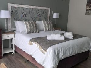 乔治Breathe Inn的一间卧室配有一张大床和毛巾
