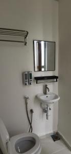 阿罗士打Tang Hotel的一间带卫生间、水槽和镜子的浴室