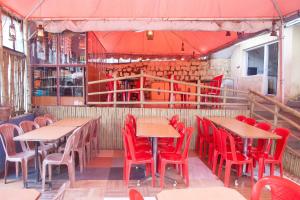 乌提Flagship Key 2 Heaven的一间空餐厅,配有桌子和红色椅子
