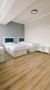 阿拉木图Khan Plaza的大客房铺有木地板,配有两张床。