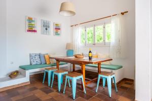 伊维萨镇坎派普托尼别墅的一间带木桌和蓝色椅子的用餐室