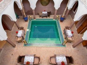 马拉喀什玛格达及Spa传统庭院住宅的配有桌椅的客房享有游泳池的顶部景致。