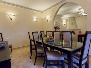 马拉喀什玛格达及Spa传统庭院住宅的用餐室配有桌椅和一碗水果
