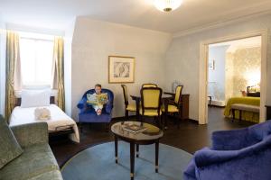布鲁塞尔斯坦霍普酒店 - 索恩酒店旗下的坐在客厅里蓝色椅子上的人