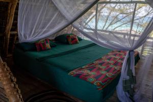 Mbweni琼碧岛珊瑚礁公园度假村的配有蚊帐的客房内的一张床位