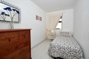 拉达祖尔Bonita vivienda con vistas al mar playaWIFI的一间卧室配有一张床、一个梳妆台和一扇窗户。
