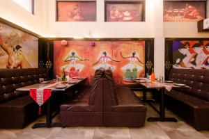 孟买Hotel Phoenix的用餐室设有两张桌子和皮革座椅。