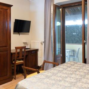 巴巴莱斯科卡萨尼可里尼酒店的一间卧室配有一张床、一张书桌和一台电视
