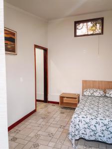 瓜佩Pousada Estância Mineira的一间卧室配有一张床、一张桌子和一个窗户。