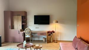 SolesmesSol'm Lodges的客厅配有书桌和墙上的电视。