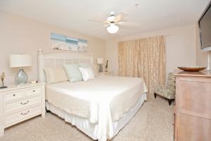 德斯坦Crystal Dunes by Panhandle Getaways的卧室配有白色的床和吊扇