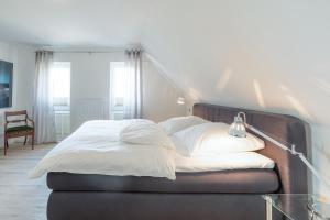 胡苏姆Vis à vis zum Schloss的一间卧室配有一张带白色床单和一盏灯的床。