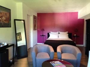 圣瑞尼安Les Chambres Lauryvan的酒店客房,配有一张床和两把椅子