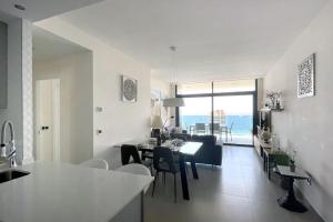 贝尼多姆Luxury apartment Residencial Sunset Drive - Benidorm, España的厨房以及带桌椅的起居室。