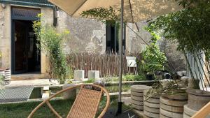Annay-sur-SereinMaison au bord de l’eau的一个带椅子和遮阳伞的庭院