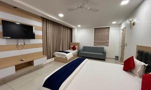 海得拉巴FabHotel Prime Anika Suites的一间酒店客房,配有一张床和一台电视