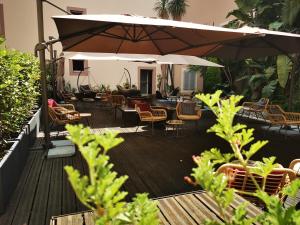 尼斯博里瓦奇酒店的庭院配有桌椅和遮阳伞。