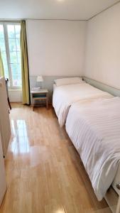 伯尔尼奈德克酒店的一间卧室配有两张床和一张边桌