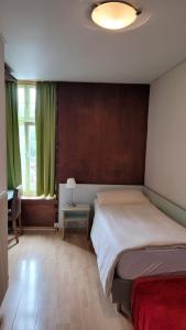 伯尔尼奈德克酒店的一间卧室配有一张床和一张带台灯的桌子