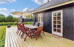 斯劳厄尔瑟Gorgeous Home In Slagelse With Wifi的木制甲板配有桌椅和遮阳伞