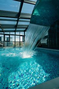 普里什蒂纳普里什蒂纳酒店的一座建筑物内带喷泉的游泳池