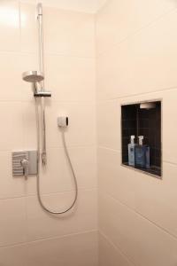 哈尔堡Appartement Burgblick的白色浴室内带软管的淋浴