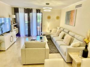 卡萨雷斯Casares Beach Golf Apartment With Private Garden Direct Pool Access的客厅设有大沙发和电视