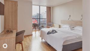 雷克雅未克Center Hotels Plaza的一间卧室配有一张床、一张书桌和一个窗户。