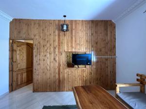 达哈布Beit Tolba的客厅设有木墙和电视