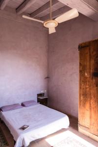 帕劳·萨巴尔德拉Ca la Merce Batista的一间卧室配有一张床和吊扇