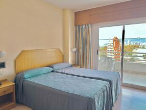 卡尔佩AR Roca Esmeralda & SPA Hotel的一间卧室设有一张床和一个美景阳台